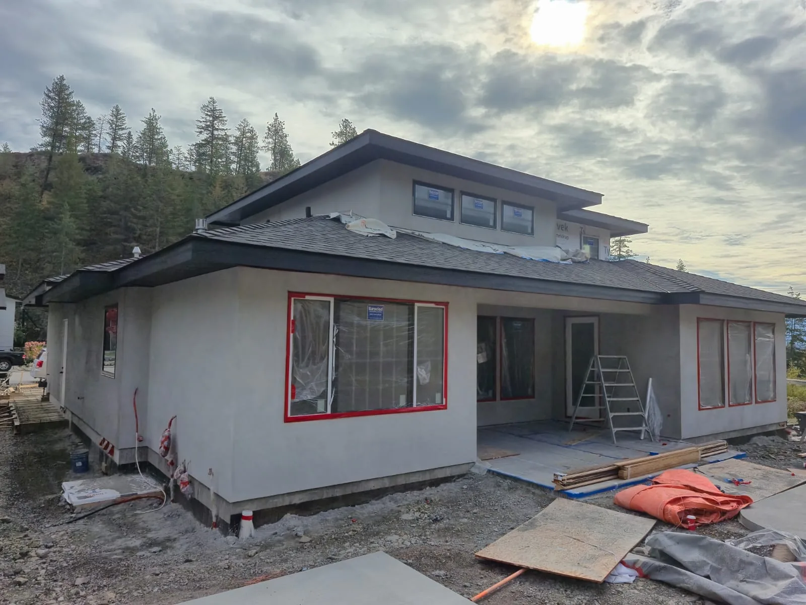 Lot 42 rear elevation mid-project, stucco walls in an earlier coat with the windows taped off in red.