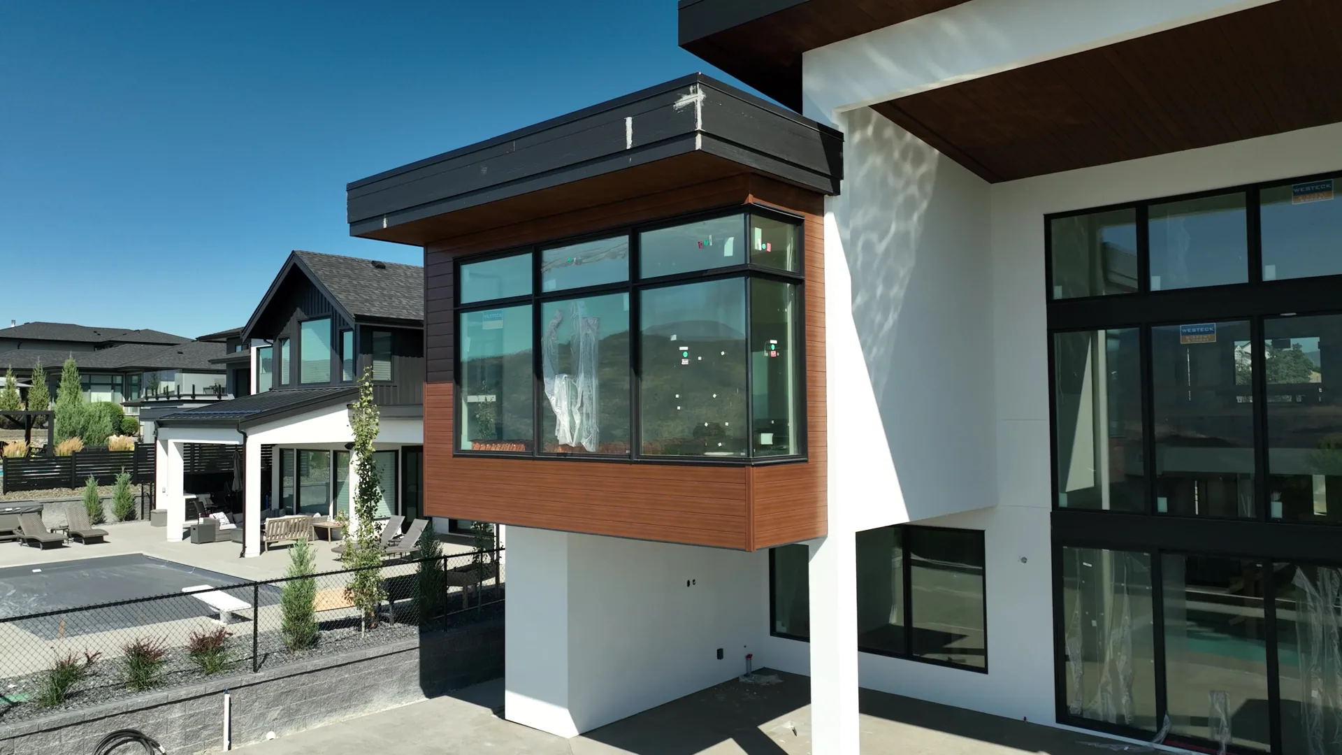 Cantilevered bay with wood siding meeting smooth stucco on a modern home.