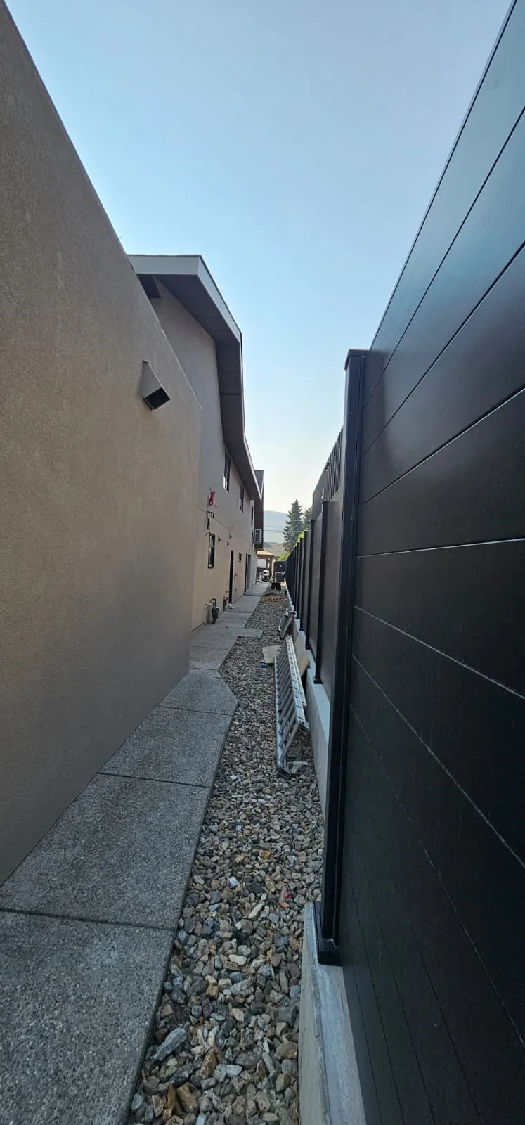 A narrow side yard beside a finished stucco wall.